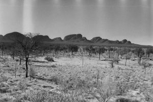 Black and white photo of Kata Tjuta in the background and scrub land in the foreground