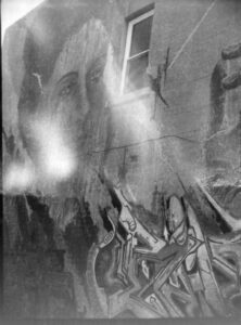 Black and white photo of street art on a laneway wall