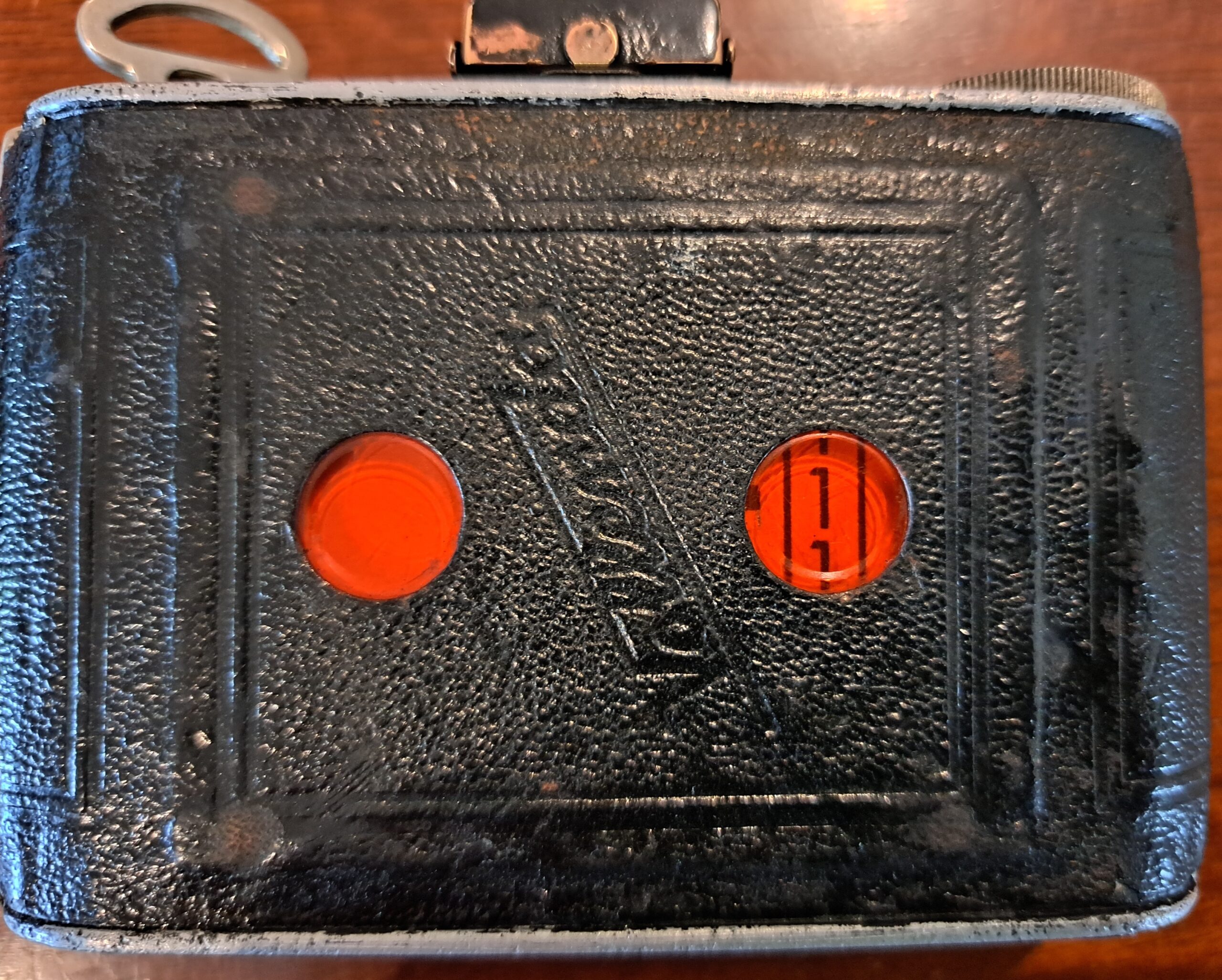Back of a vintage camera showing the two red windows where the film numbers can be seen. The number one is in the right hand window.