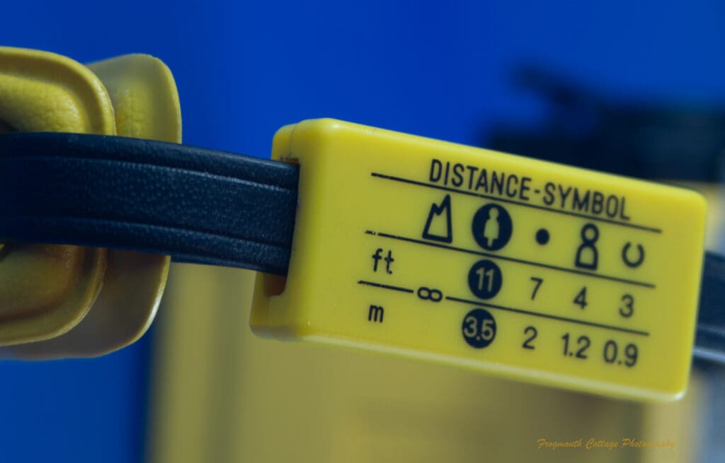 Photograph of the wrist strap distance instructions on the Minolta Weathermatic A
